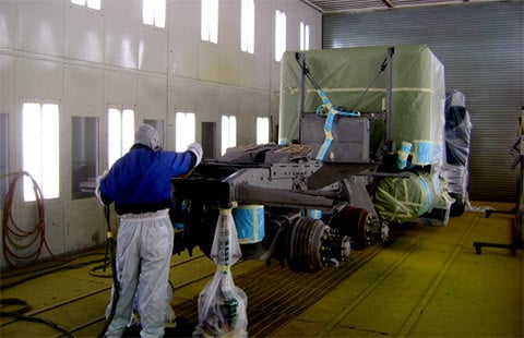AIS employee painting construction equipment